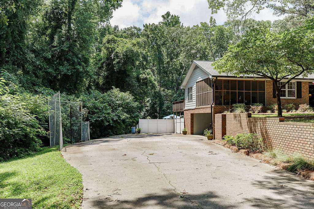 226 Baker Street Statham, GA 30666 - Photo 4 of 63 a view of a backyard with large trees and wooden fence