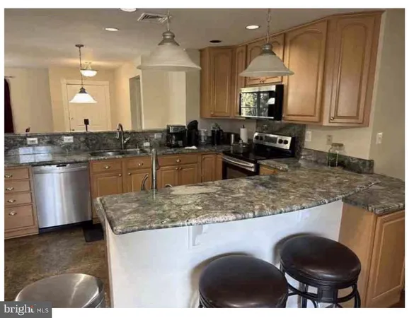a kitchen with granite countertop a sink a stove and cabinets