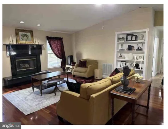 a living room with furniture a rug and a bookshelf