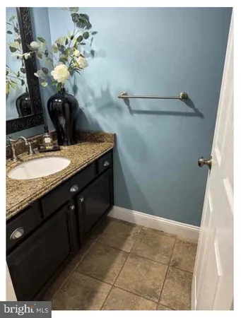 a bathroom with a granite countertop sink a toilet and mirror
