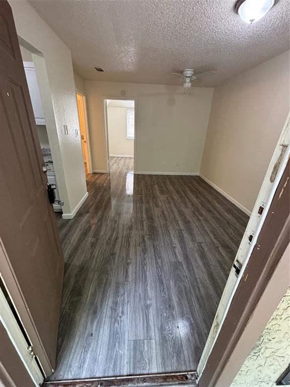 8127 Stonehurst Street, Unit 4 Dallas, TX 75217 - Photo 1 of 6 an empty room with wooden floor and windows