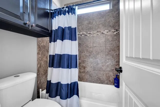 a bathroom with a granite countertop toilet sink and mirror