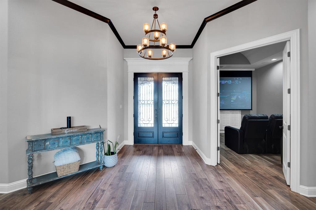 5811 Limestone Lane Midlothian, TX 76065 - Photo 28 of 40 a hallway with a dining table chairs wooden floor and front door