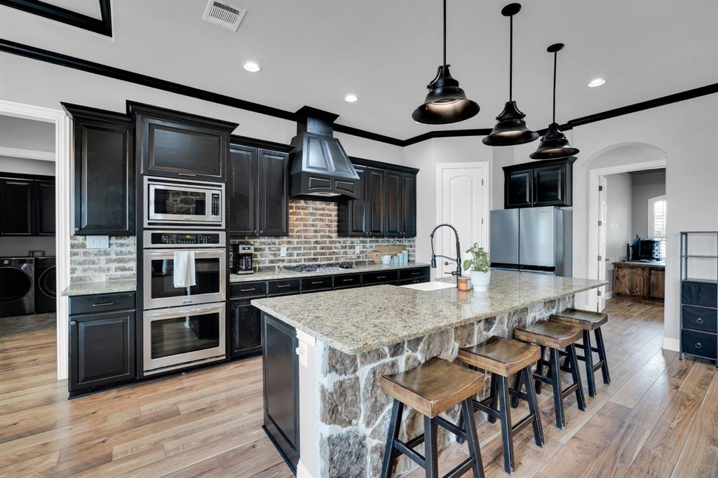 5811 Limestone Lane Midlothian, TX 76065 - Photo 33 of 40 a kitchen with stainless steel appliances granite countertop a stove and a wooden floors