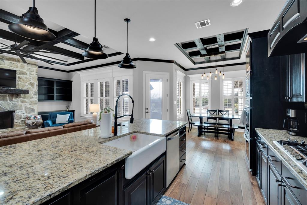 5811 Limestone Lane Midlothian, TX 76065 - Photo 34 of 40 a kitchen with stainless steel appliances granite countertop a sink a stove and a wooden floors