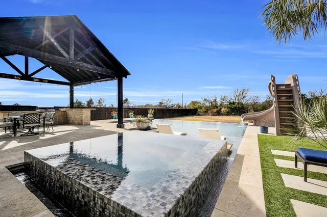 a view of a swimming pool with a patio and a garden