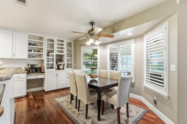 a kitchen with a stove a sink dishwasher and white cabinets with wooden floor