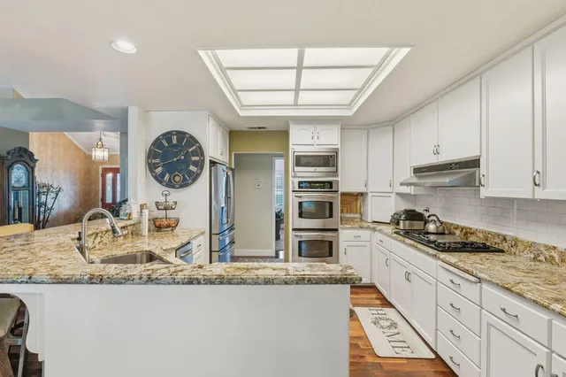 a spacious bathroom with a double vanity sink a mirror and a bathtub