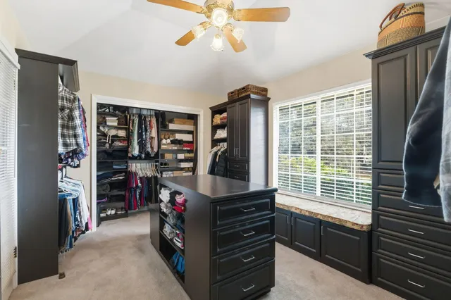 a bedroom with a bed a flat screen tv and a chandelier