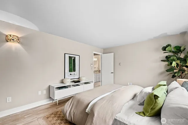 a bedroom with a bed and a potted plant