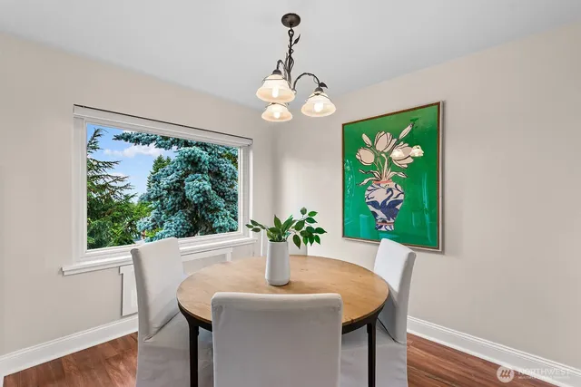 a dining room with furniture a large window and wooden floor