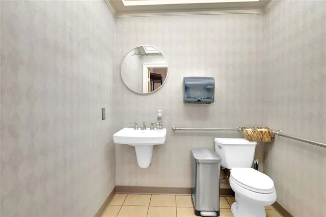 a bathroom with a toilet a sink and mirror