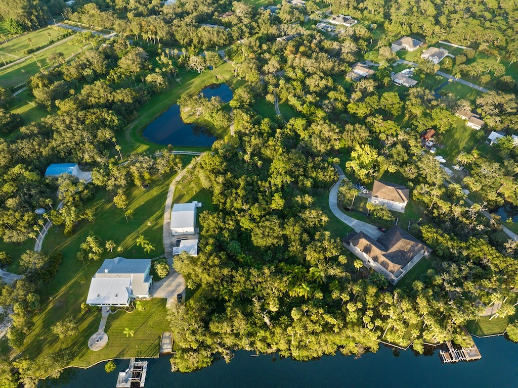 an aerial view of residential houses with outdoor space and trees