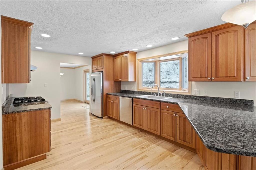 32 Canter Drive Sewickley, PA 15143 - Photo 7 of 25 a kitchen with stainless steel appliances granite countertop a stove a sink dishwasher and a refrigerator with wooden floor