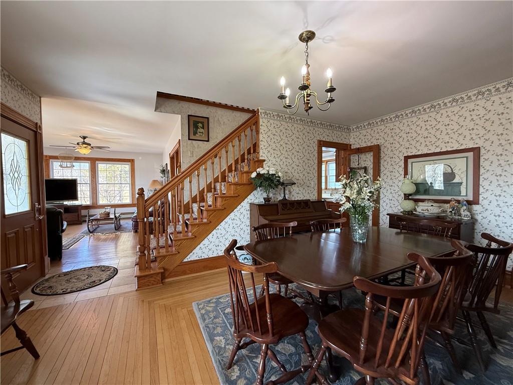 172 Valley Road Cranberry, PA 16319 - Photo 17 of 50 a dining room with wooden floor a chandelier a wooden table and chairs
