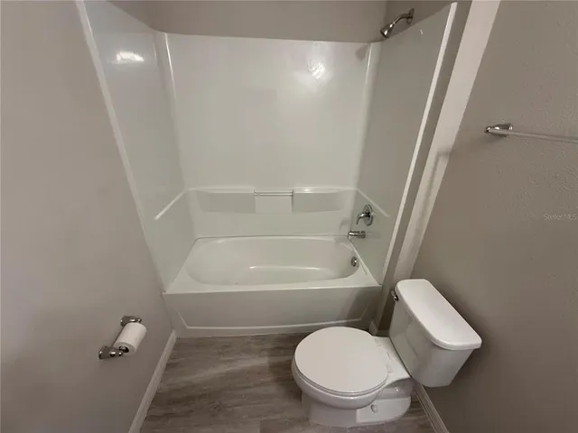 a white toilet sitting next to a bath tub