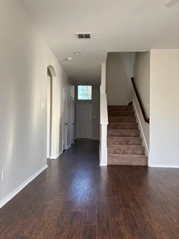 a view of a hallway with wooden floor and stairs