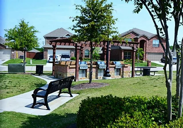 a house view with a garden space and patio