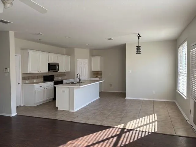 a kitchen with granite countertop a refrigerator sink and cabinets