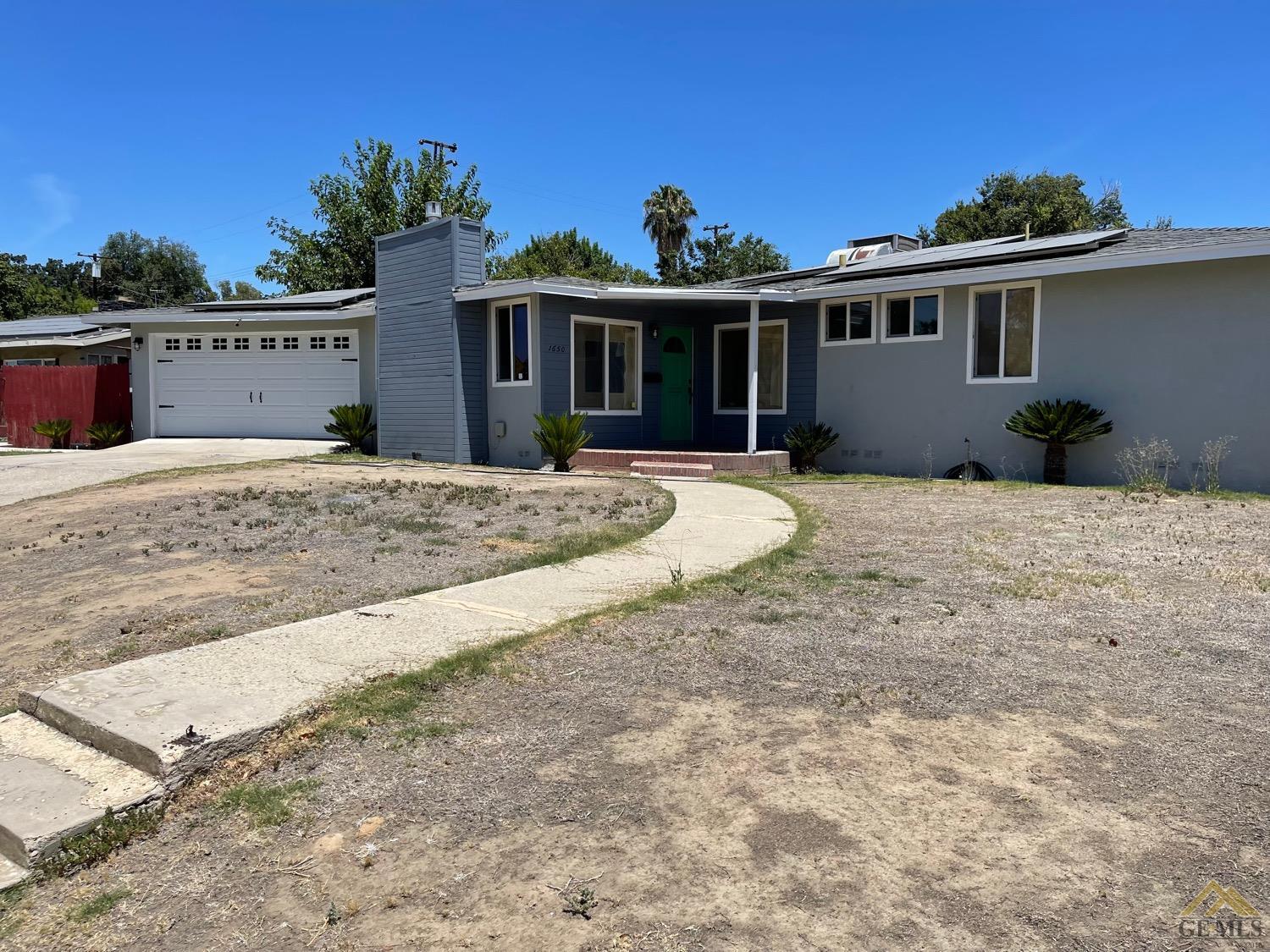 a view of a house with backyard and sitting area