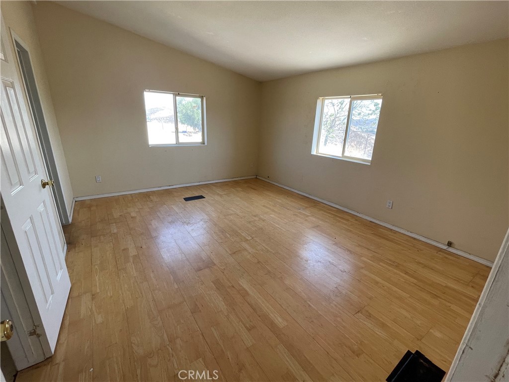 18600 Chippewa Road Lake Elsinore, CA 92532 - Photo 7 of 18 a view of an empty room with wooden floor and a window