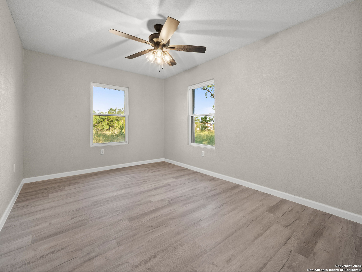 19551 Farm To Market Road 463 Devine, TX 78016 - Photo 13 of 27 wooden floor in an empty room with a window