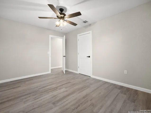 a view of an empty room with wooden floor