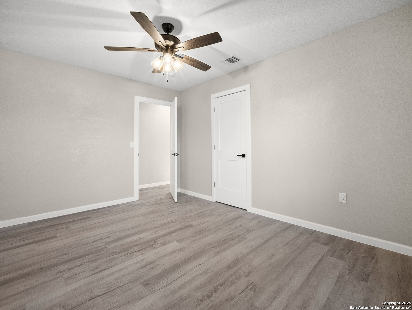 19551 Farm To Market Road 463 Devine, TX 78016 - Photo 14 of 27 a view of an empty room with wooden floor