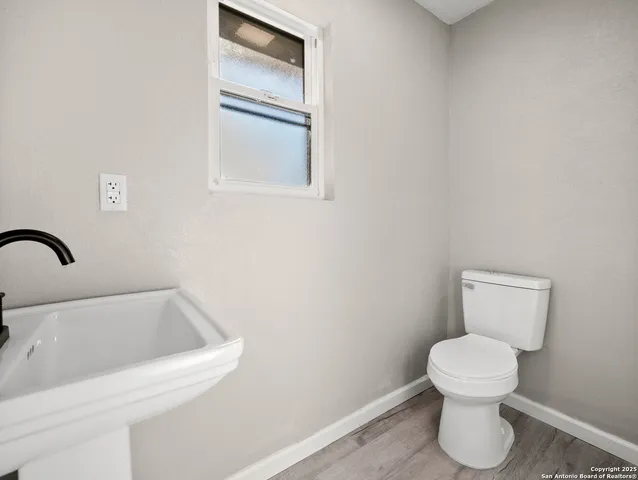 a bathroom with a toilet sink and mirror