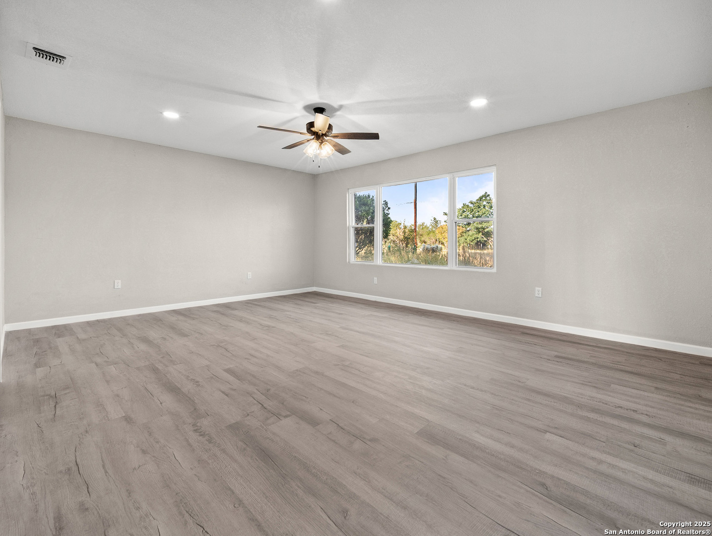 19551 Farm To Market Road 463 Devine, TX 78016 - Photo 18 of 27 wooden floor in an empty room with a window