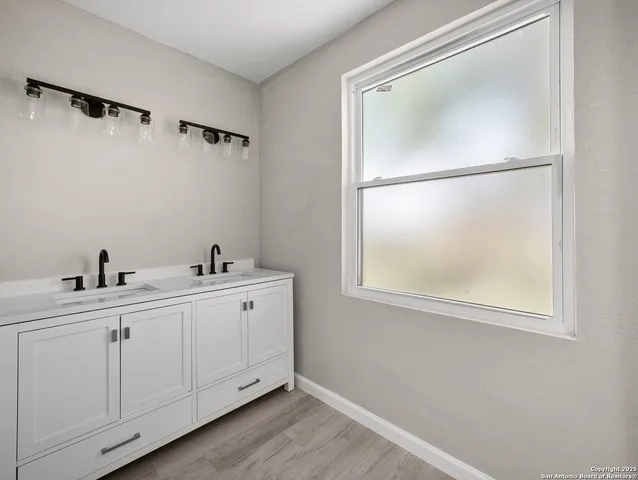 a bathroom with a double vanity sink and mirror