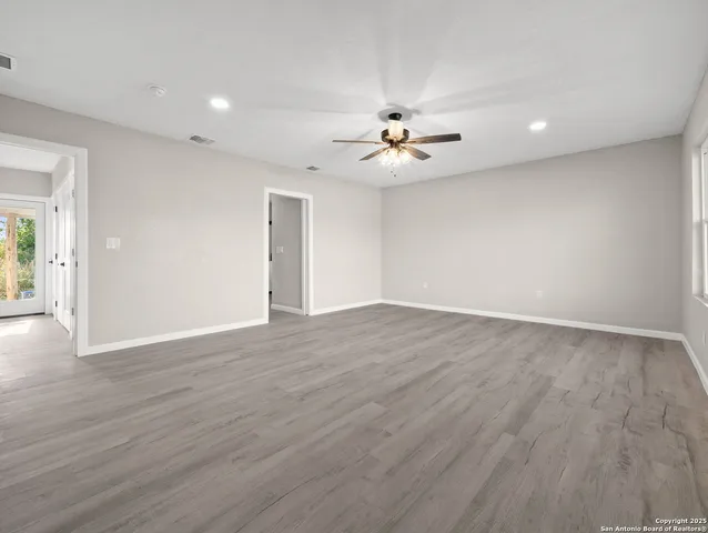a view of an empty room with wooden floor