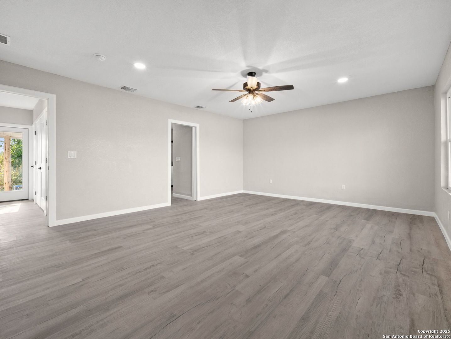 19551 Farm To Market Road 463 Devine, TX 78016 - Photo 23 of 27 a view of an empty room with wooden floor