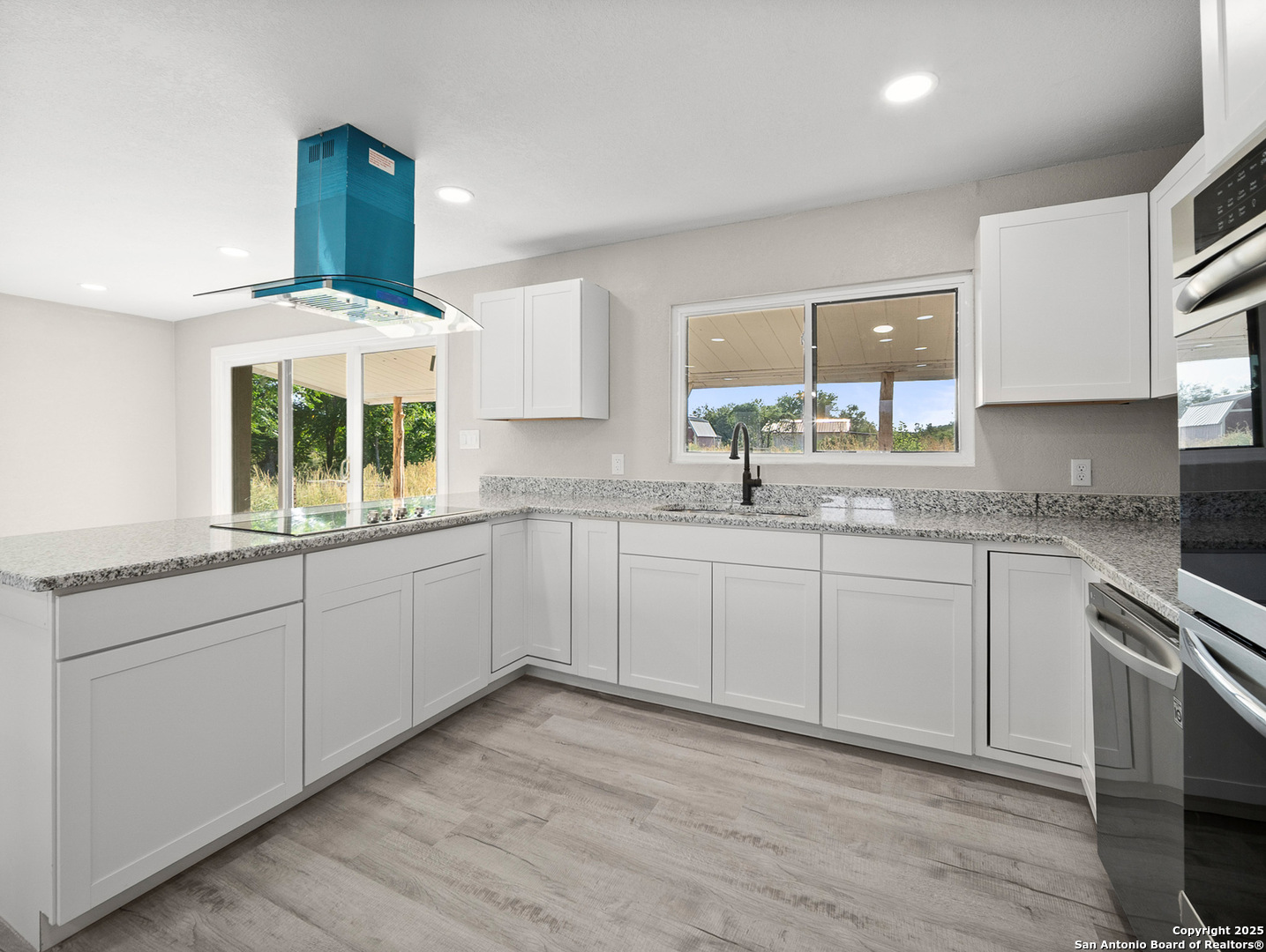 19551 Farm To Market Road 463 Devine, TX 78016 - Photo 6 of 27 a kitchen with granite countertop white cabinets and white appliances