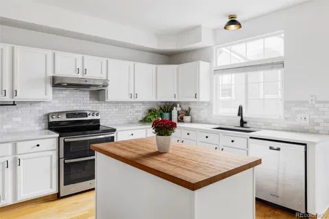 a kitchen with stainless steel appliances granite countertop a sink stove and cabinets