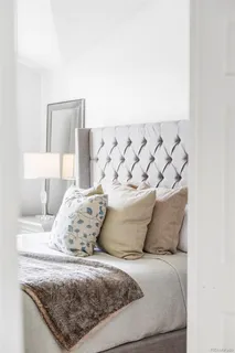 a bedroom with a bed and a painting on the wall