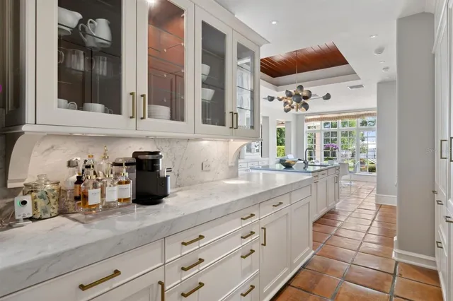 a kitchen with granite countertop a white cabinets and chairs