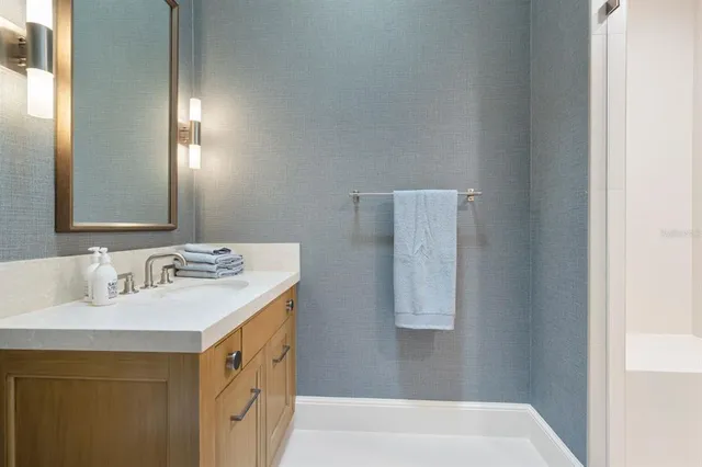 a bathroom with a granite countertop sink a toilet and a mirror