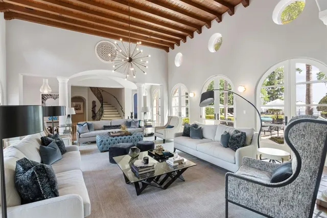 a living room with furniture chandelier and a fireplace