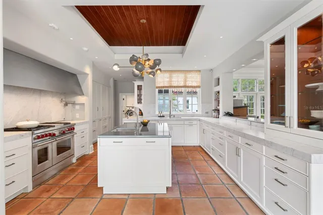 a kitchen with a stove a sink dishwasher and a stove with wooden floor