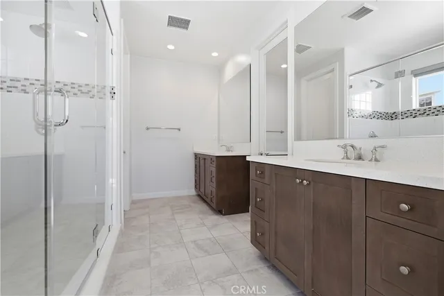a bathroom with a double vanity sink a mirror and shower