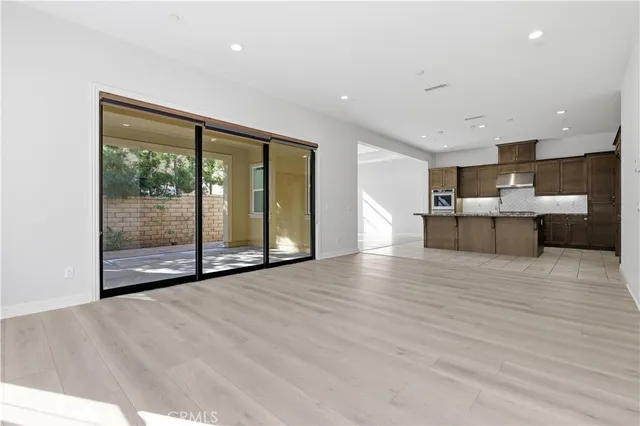 a view of empty room with wooden floor and floor to ceiling window