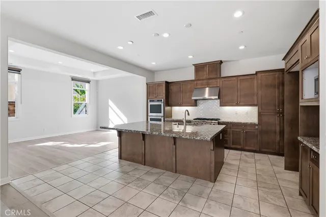 a kitchen with stainless steel appliances granite countertop a sink and a stove