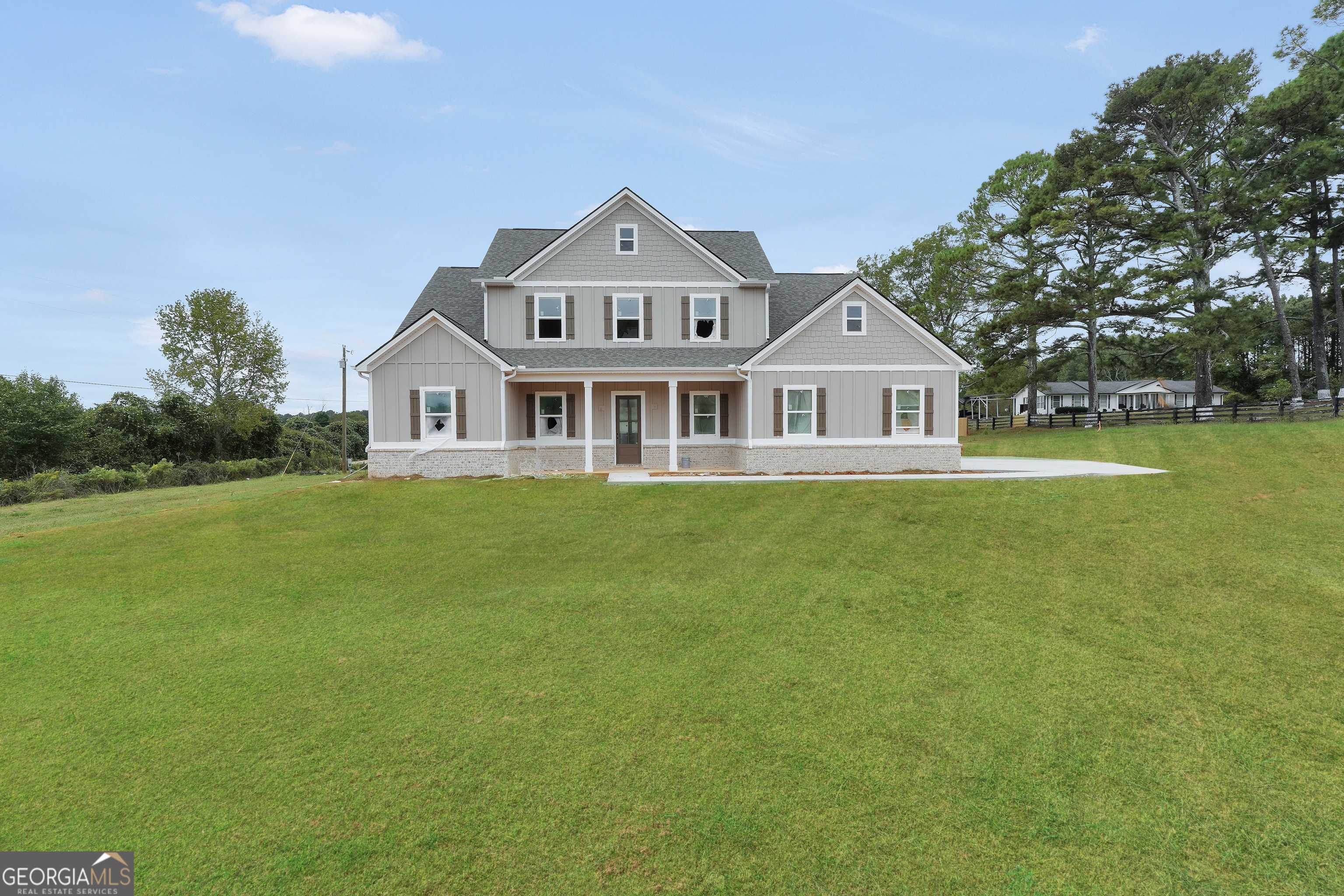 a front view of a house with a garden and lake view