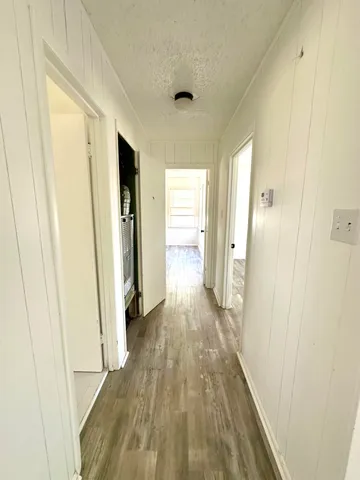 a view of a hallway with wooden floor and closet