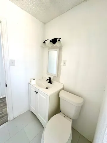 a bathroom with a toilet a sink and mirror