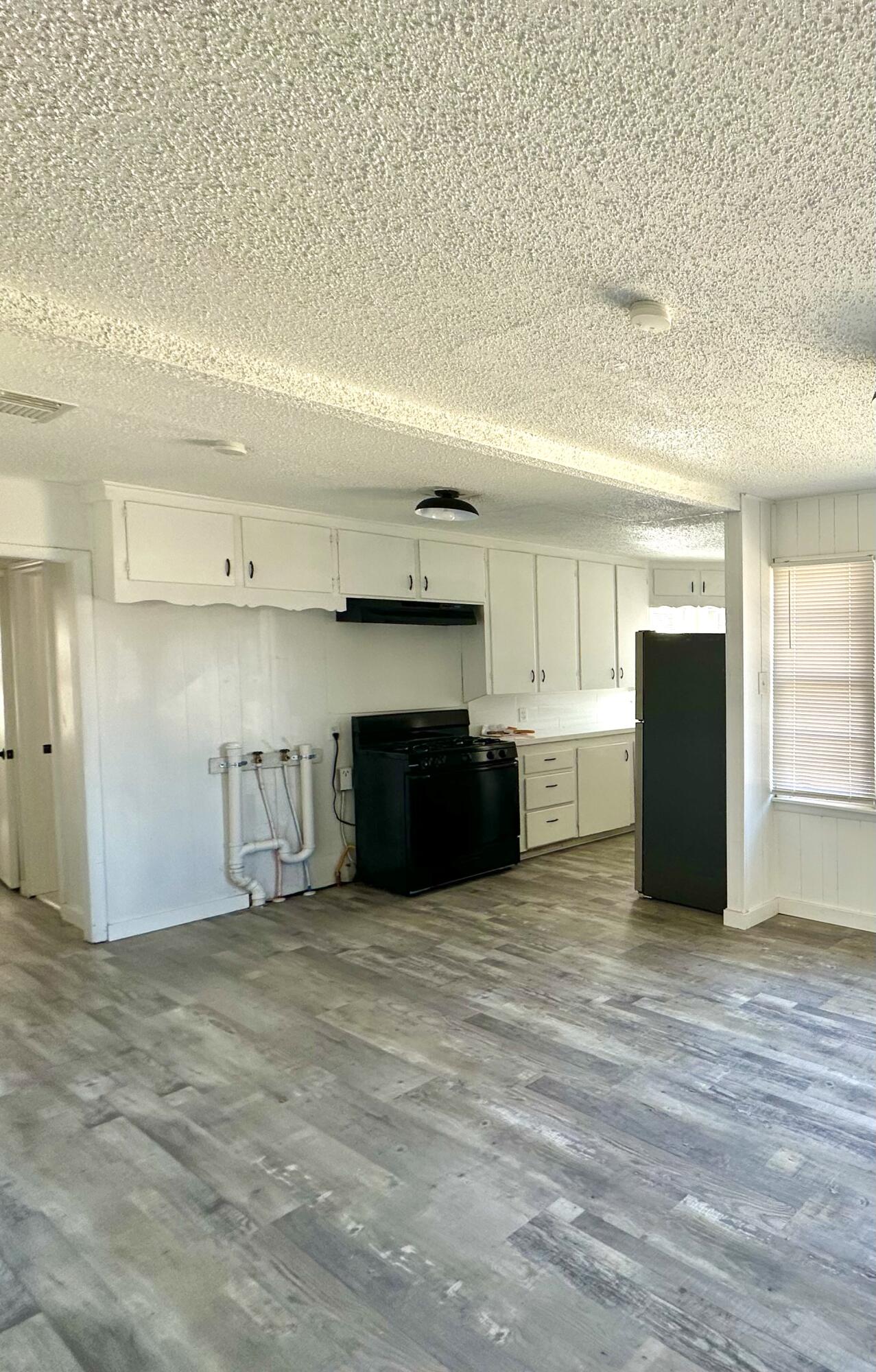 1827 8th Street Levelland, TX 79336 - Photo 9 of 25 a view of an empty room with kitchen and a window