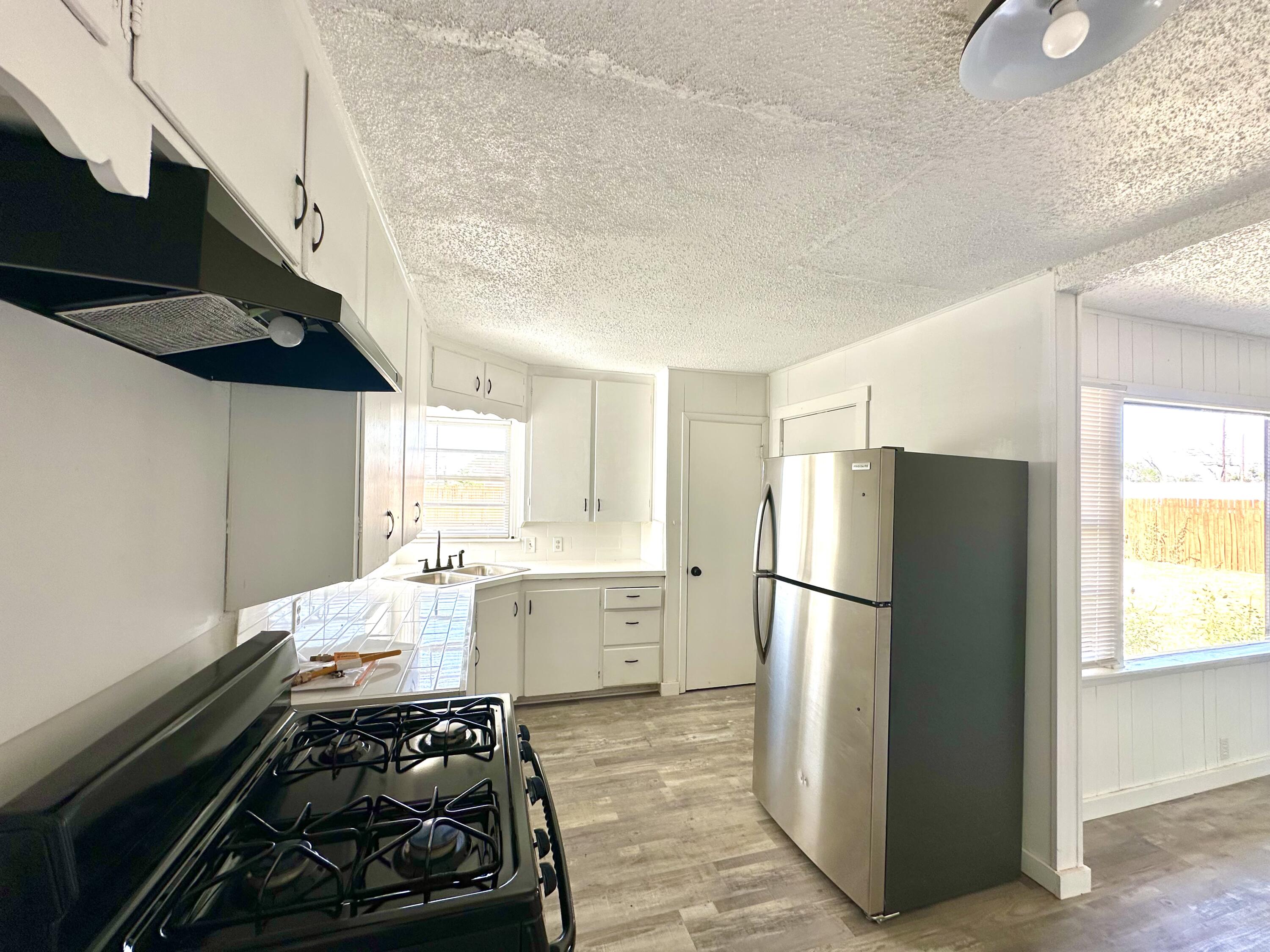 1827 8th Street Levelland, TX 79336 - Photo 10 of 25 a kitchen with a refrigerator and a stove