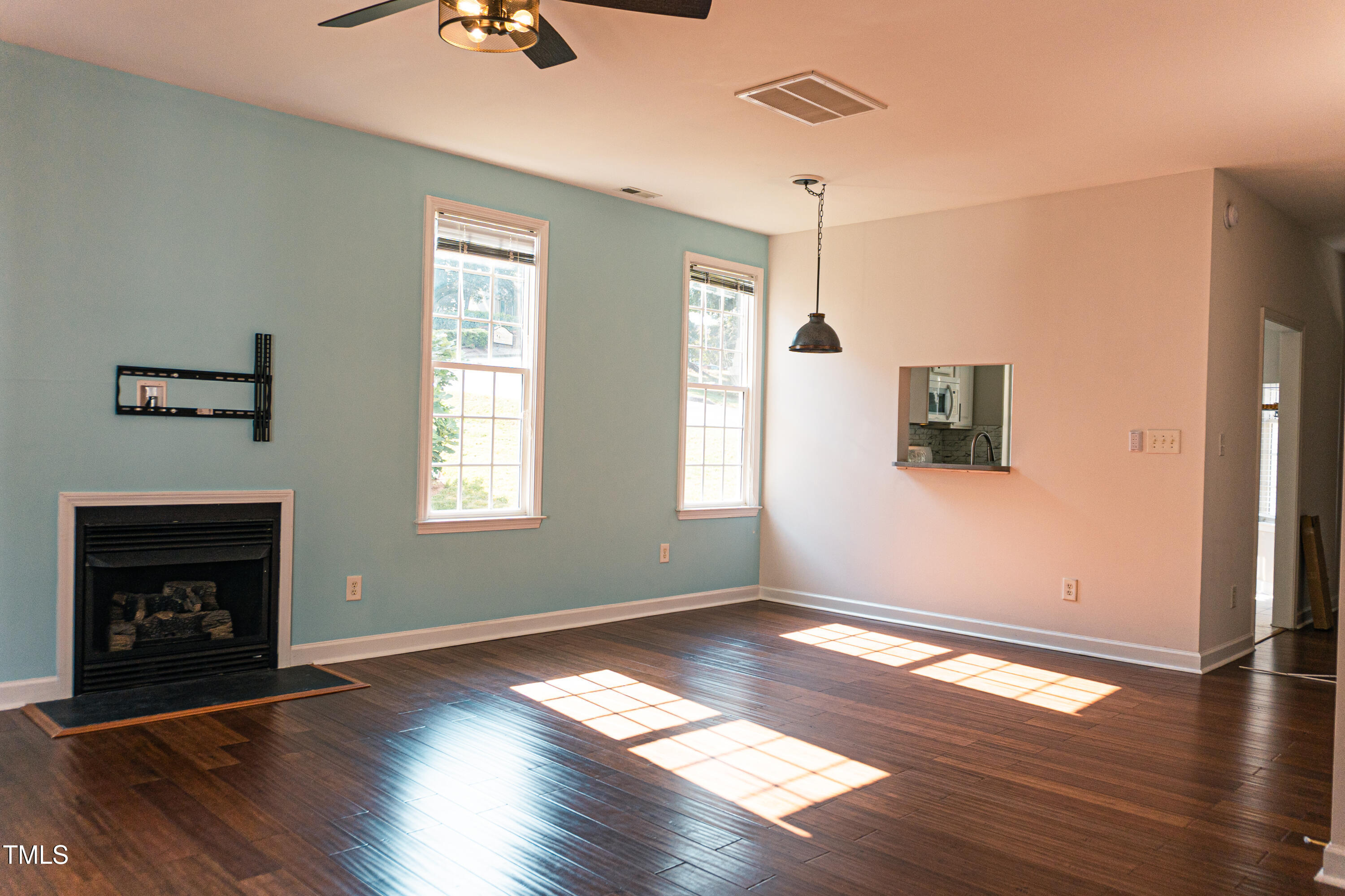 2271 Trailwood Valley Circle Raleigh, NC 27603 - Photo 12 of 36 a view of an empty room with wooden floor fireplace and a window