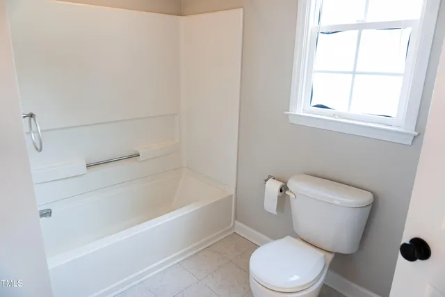 a white toilet sitting next to a bath tub
